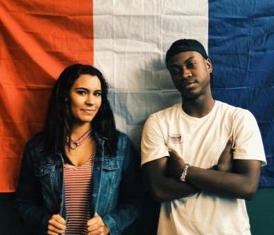 南加州大学上州法语俱乐部官员站在法国国旗前的照片